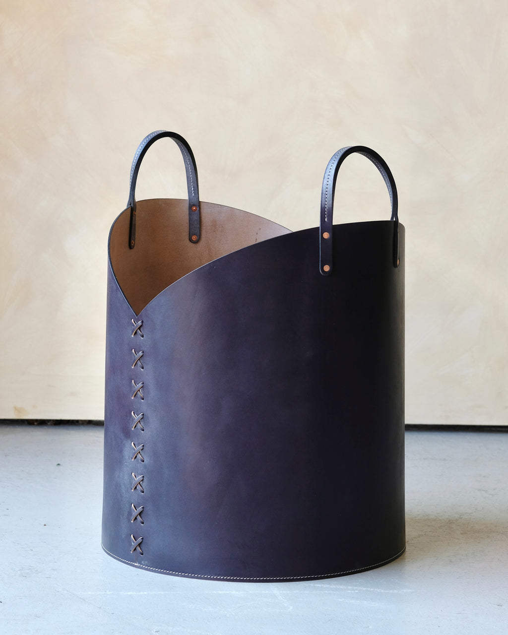 Navy leather basket with handles on a light background