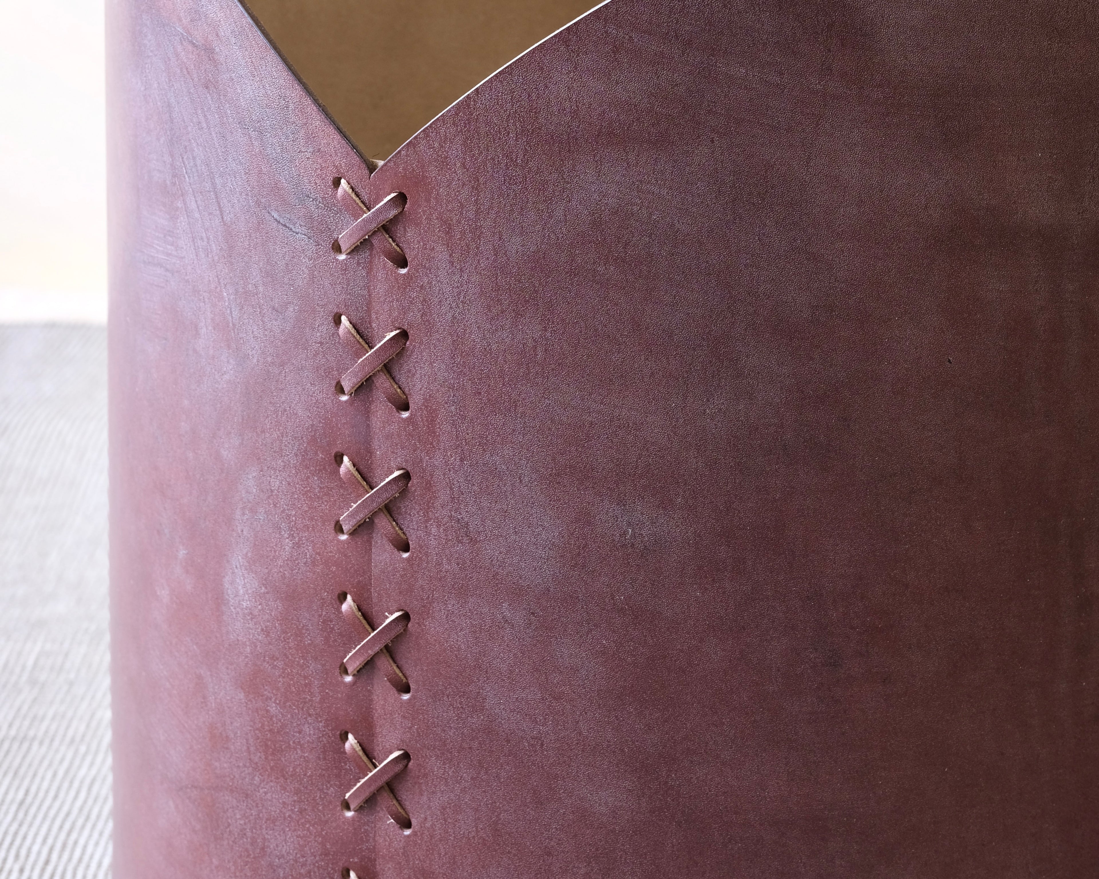 Close-up of a burgundy leather log basket