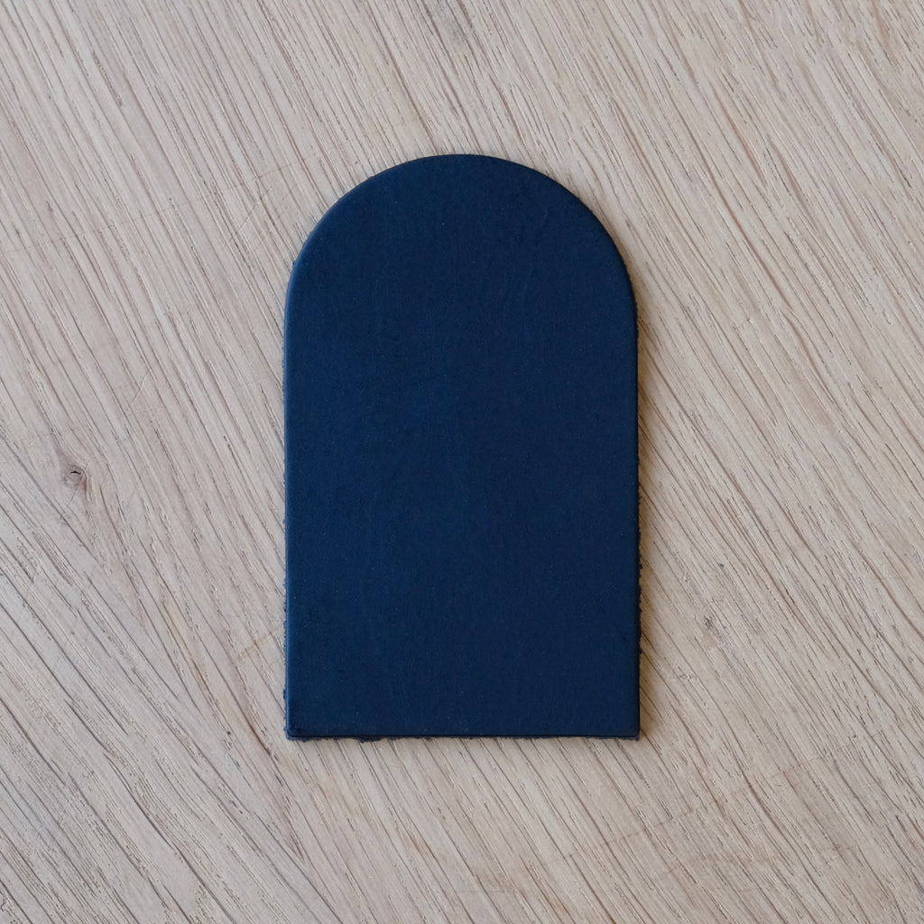 Navy blue leather patch on a wooden surface