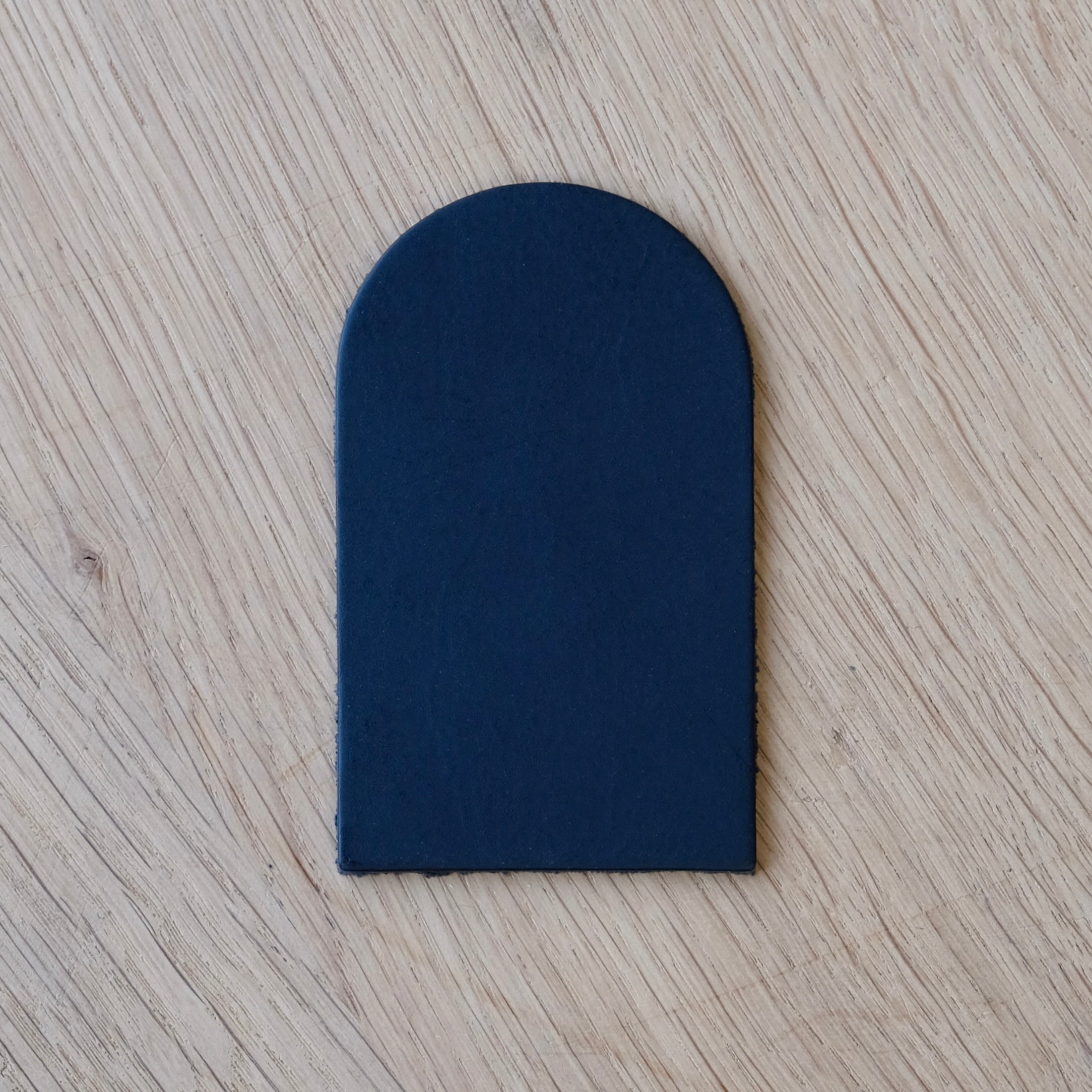 Navy blue leather patch on a wooden surface