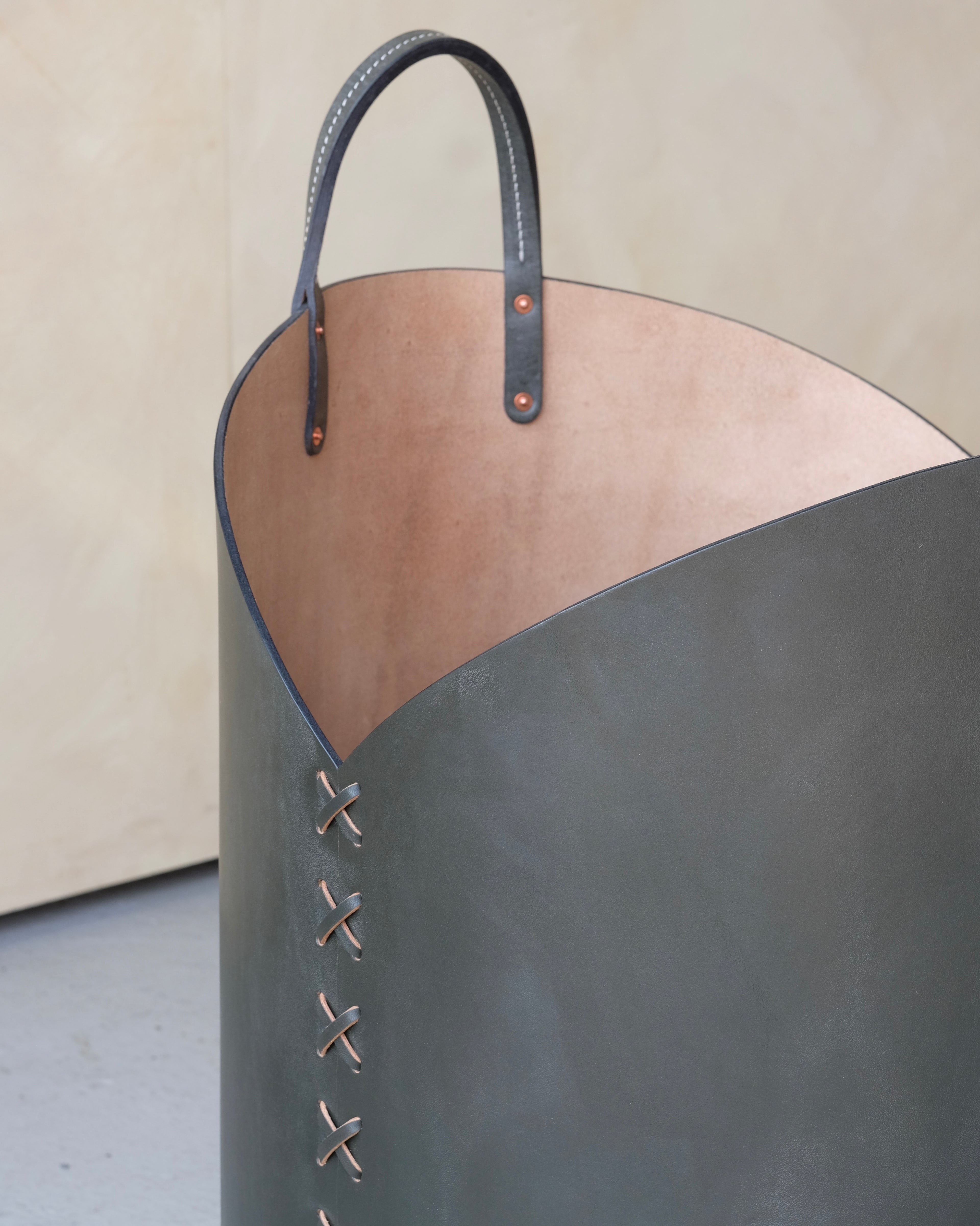 Kelp Green leather log basket with a beige interior on a neutral background