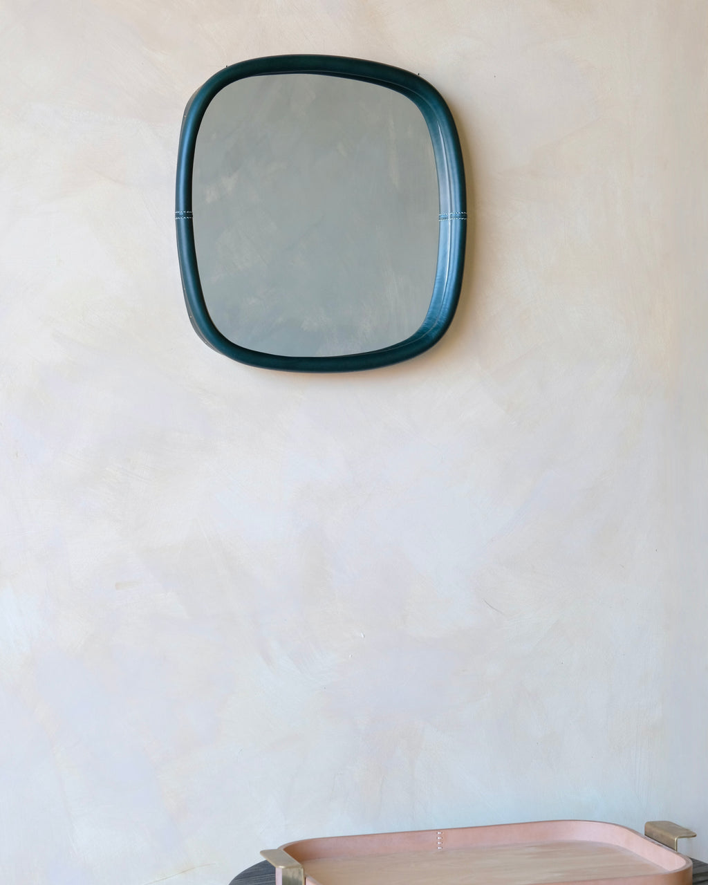 small square mirror with oliva frame on a white wall