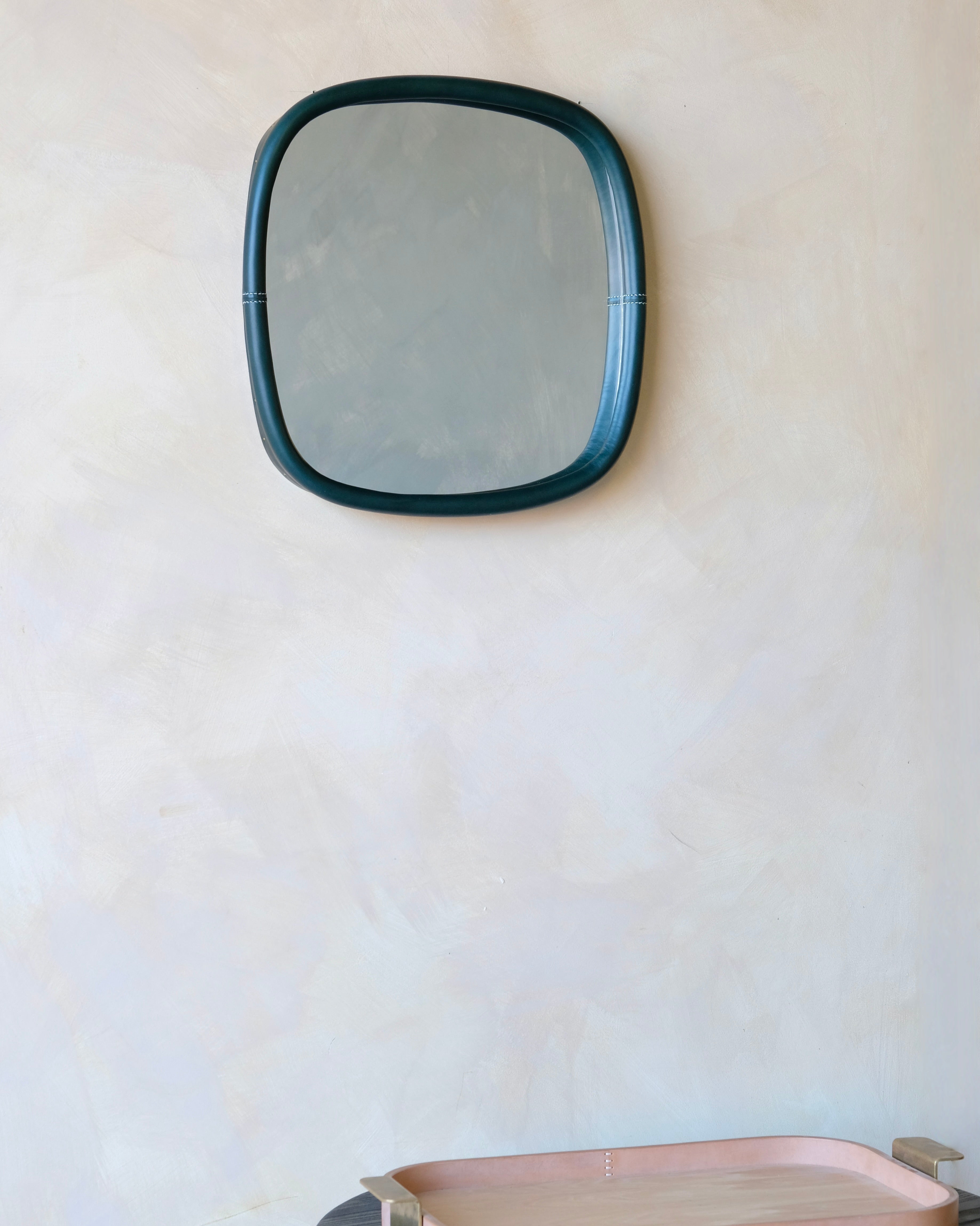 small square mirror with oliva frame on a white wall