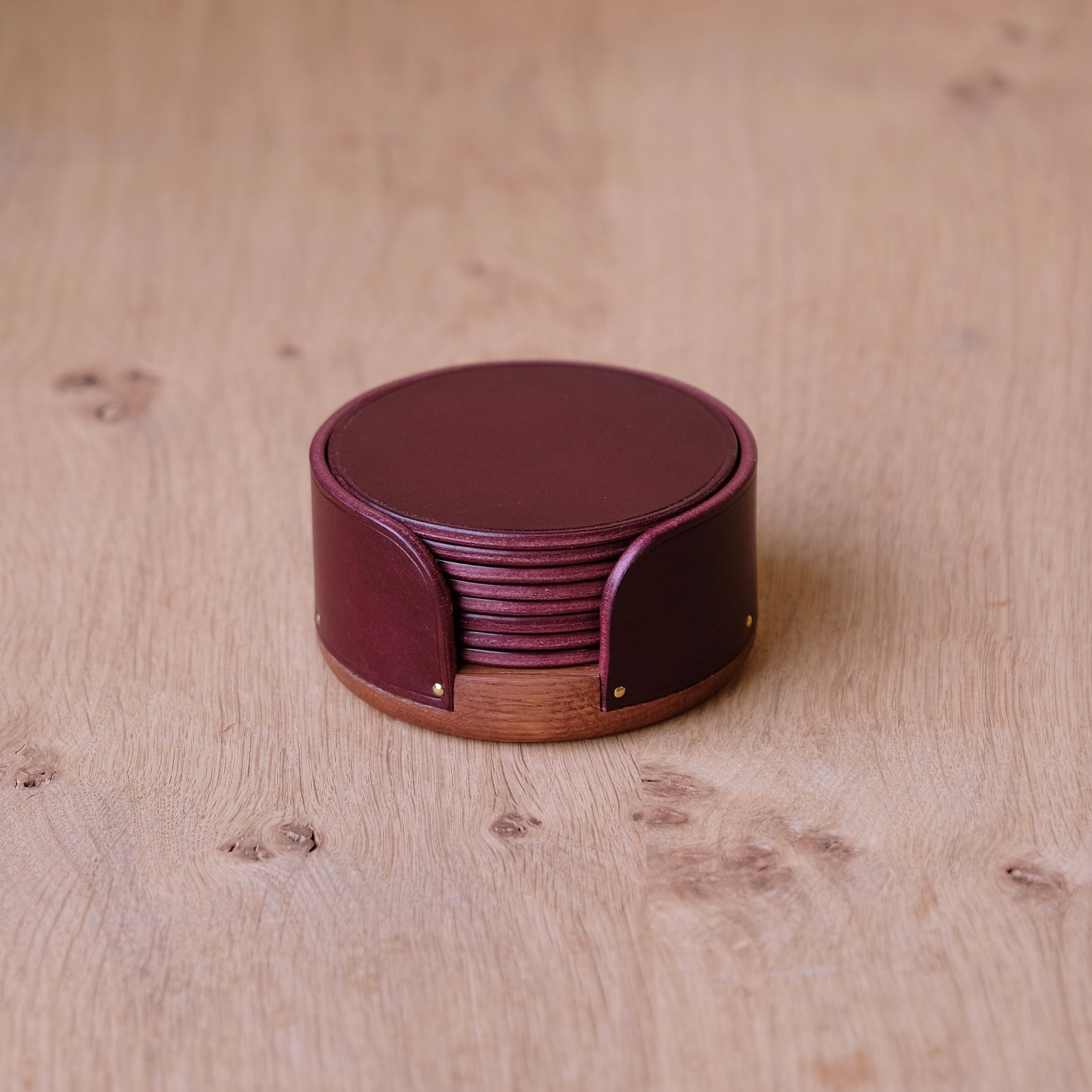 Set of round leather coasters on a wooden surface