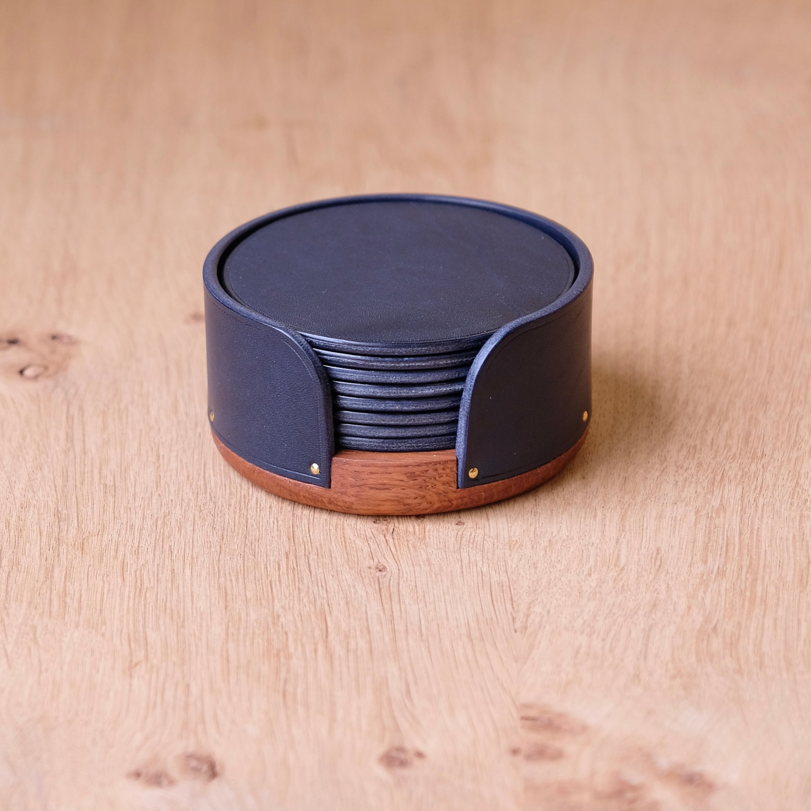Set of blue coasters in a wooden holder on a wooden surface