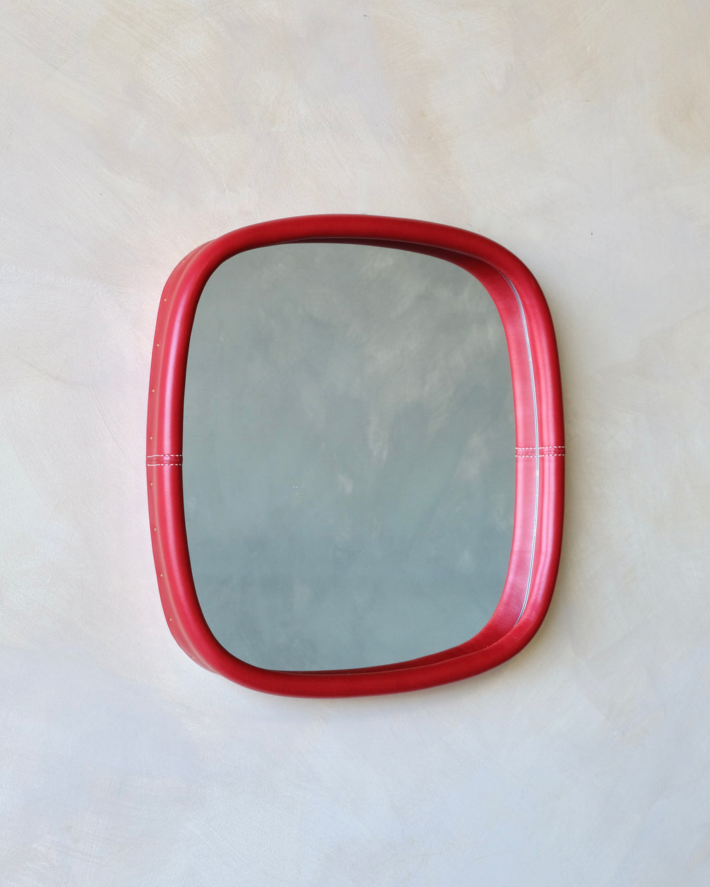 Rectangular mirror with a red leather frame on a white background